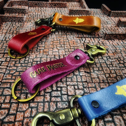 Handcrafted leather mystery keychain assortment with heavy-duty steel hardware for FLGS point of purchase retail counter displays.