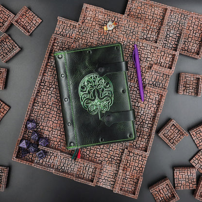 Handmade leather A5 TTRPG adventure journal for D&D campagin notes, shown next to polyhedral RPG dice on a tabletop gaming setup.