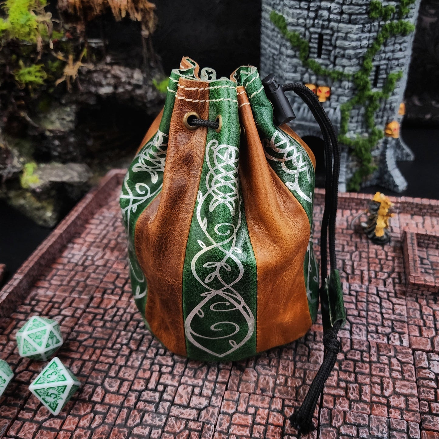 Handcrafted tan and deep green buffalo hide standing round D&D dice bag with gilded Elven scrollwork design by Grimbeard Leather.
