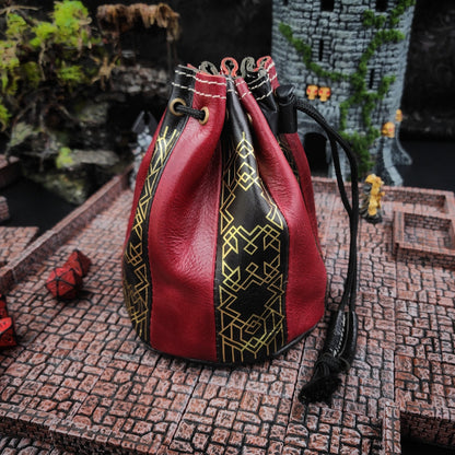 Handcrafted black and red buffalo hide standing round D&D dice bag with gilded Dwarven line work design by Grimbeard Leather.