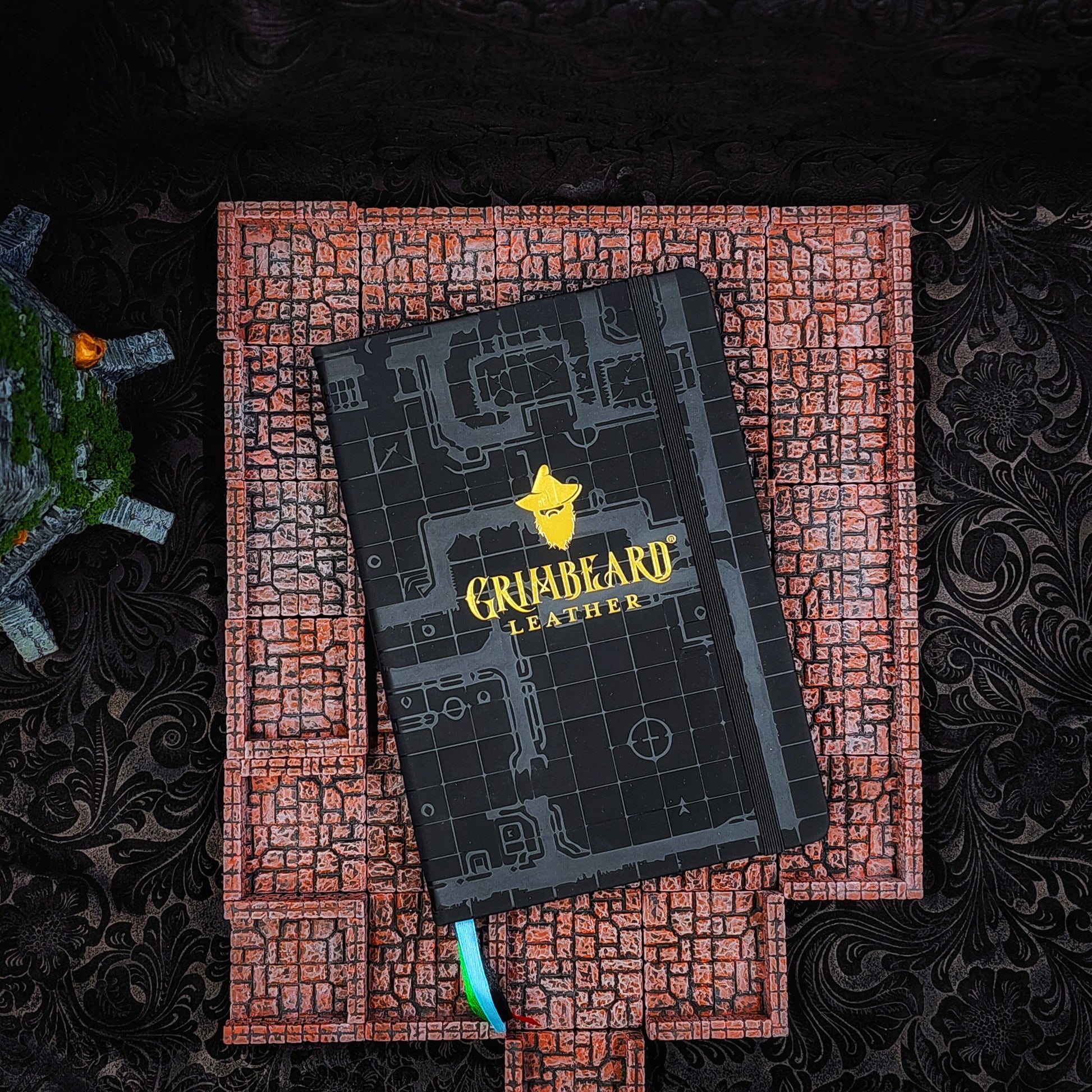 Hardcover black A5 large adventure journal refill insert featuring an embossed dungeon grid and gilded gold or silver foil Grimbeard Leather logo.