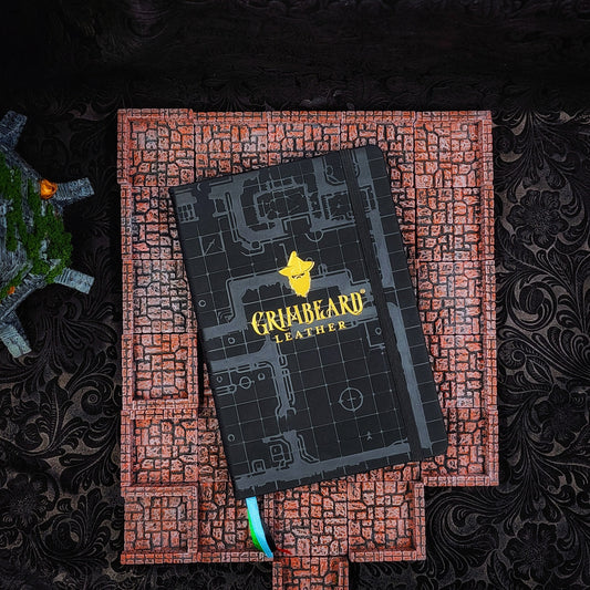 Hardcover black A5 large adventure journal refill insert featuring an embossed dungeon grid and gilded gold or silver foil Grimbeard Leather logo.