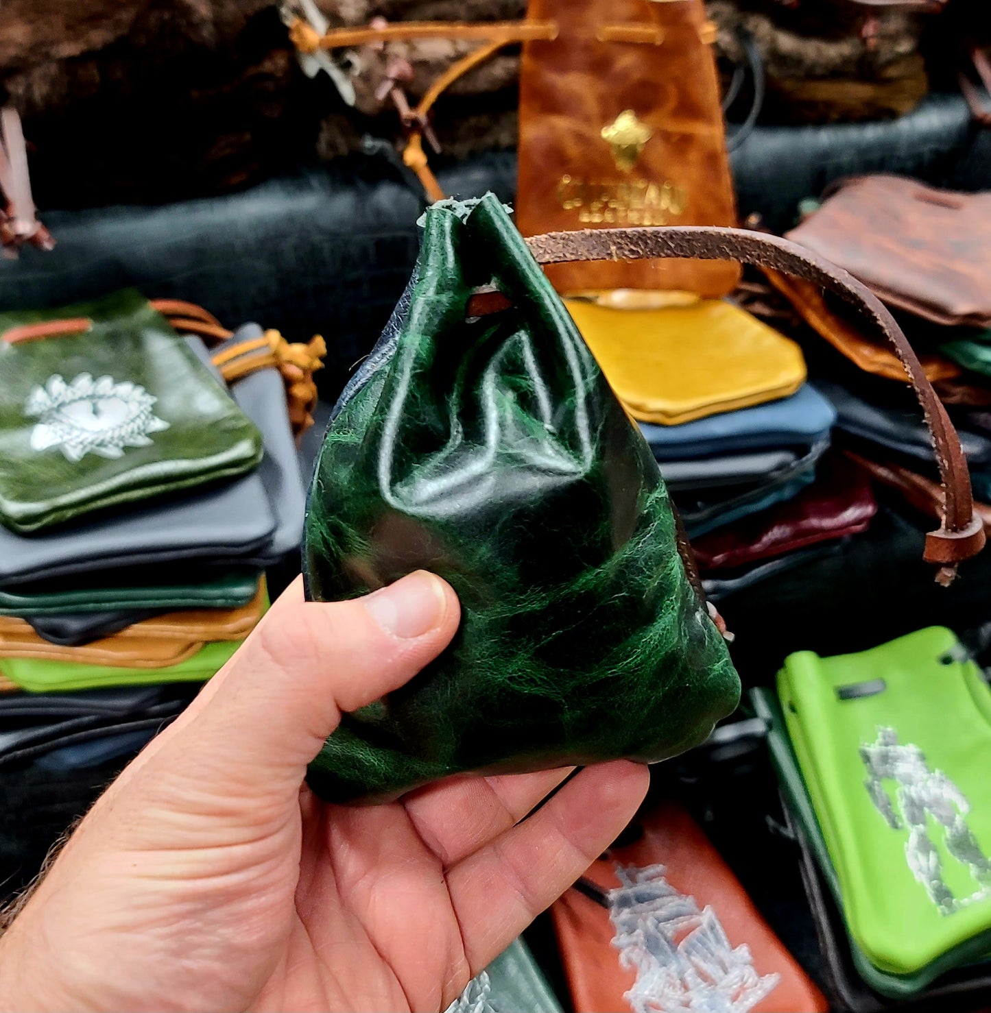 Handcrafted small flat leather dice bags in a bulk random assortment for D&D game shops and Renaissance festival vendor counters.