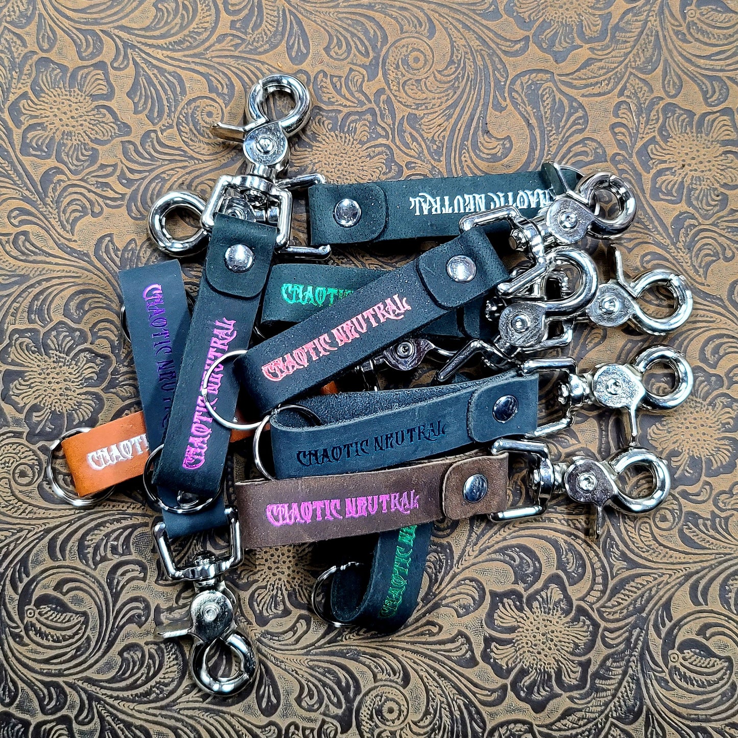 Handcrafted leather alignment keychain with hand-gilded tabletop RPG alignment system text and steel hardware for FLGS point of purchase retail counter displays.