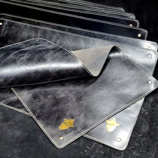 Handcrafted leather playmat and TTRPG battle mat with steel corner rivets and polyhedral RPG dice layout for retail game shops.