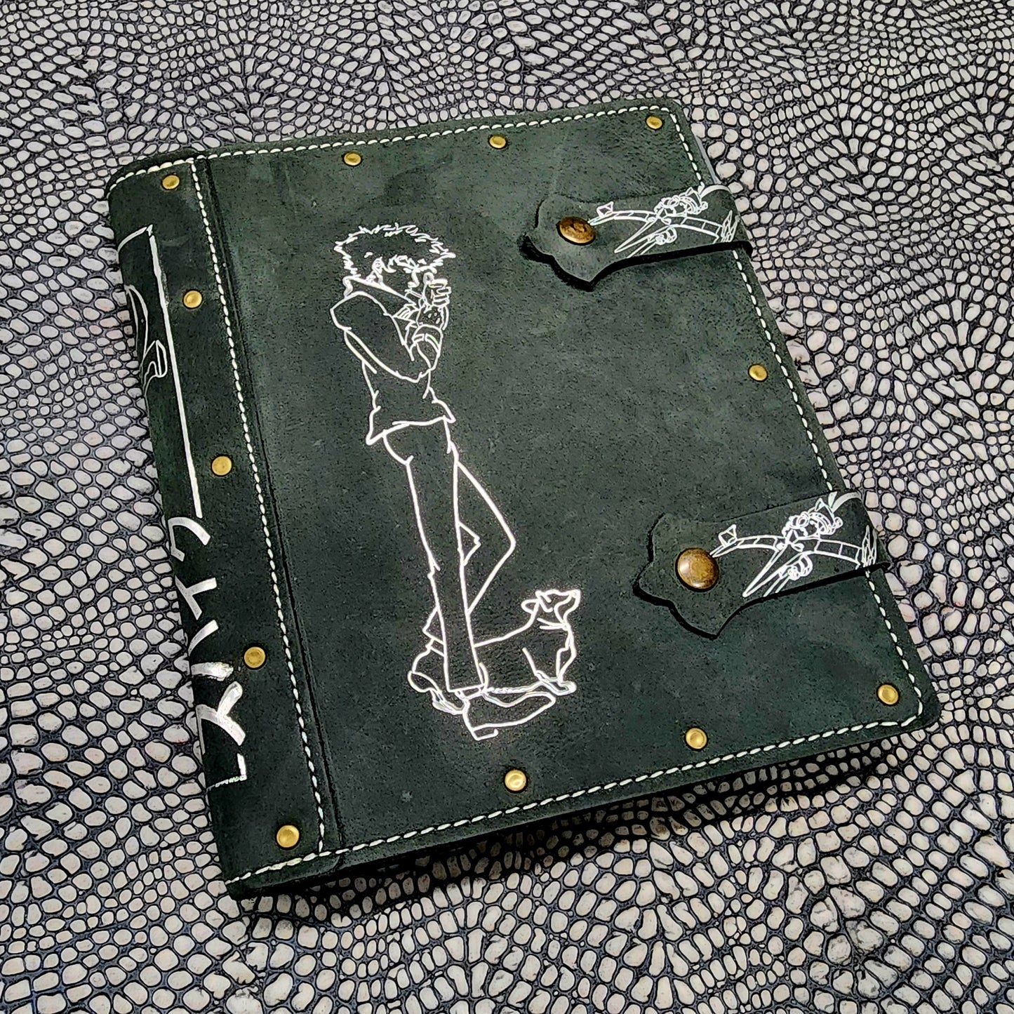 Handmade leather 4 pocket TCG card binder cover for trading card collections, shown next to polyhedral RPG dice on a tabletop gaming setup.