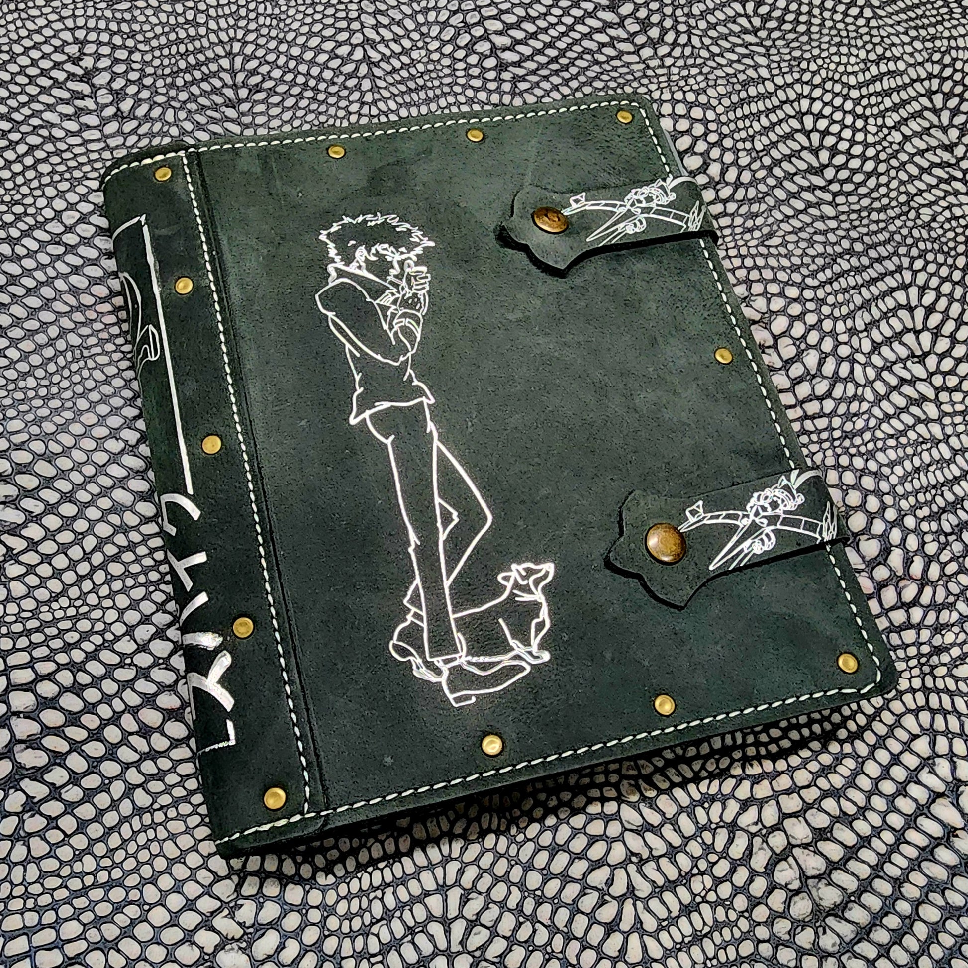 Handmade leather 4 pocket TCG card binder cover for trading card collections, shown next to polyhedral RPG dice on a tabletop gaming setup.