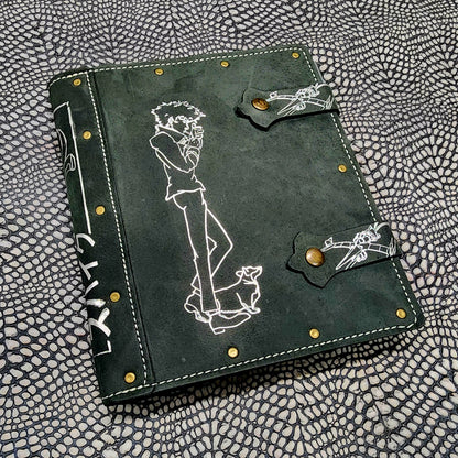 Handmade leather 4 pocket TCG card binder cover for trading card collections, shown next to polyhedral RPG dice on a tabletop gaming setup.