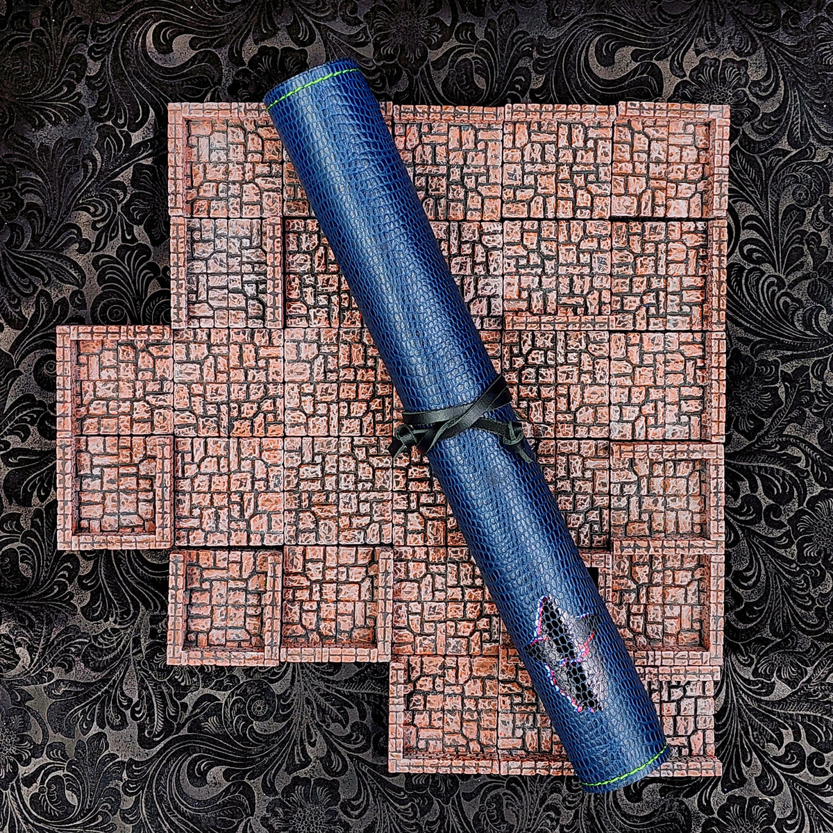 Handcrafted limited edition textured leather playmats, including blue lizard-print and metallic gold dragon hide patterns, center-cut for premium D&D and TCG gaming setups.