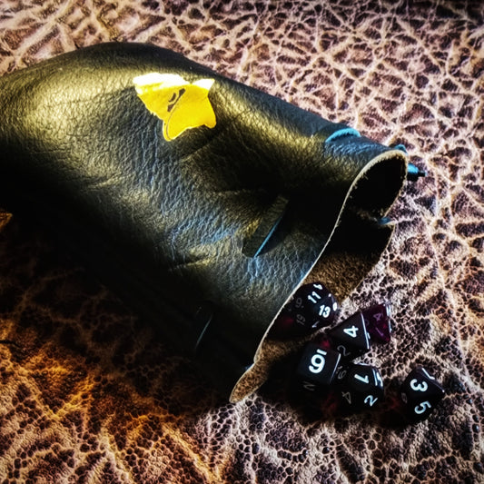 Handcrafted leather dice bags in earthtones, blacks, grays, reds, blues, greens, purples, pinks, yellows, and golds for D&D players and retail store counters.