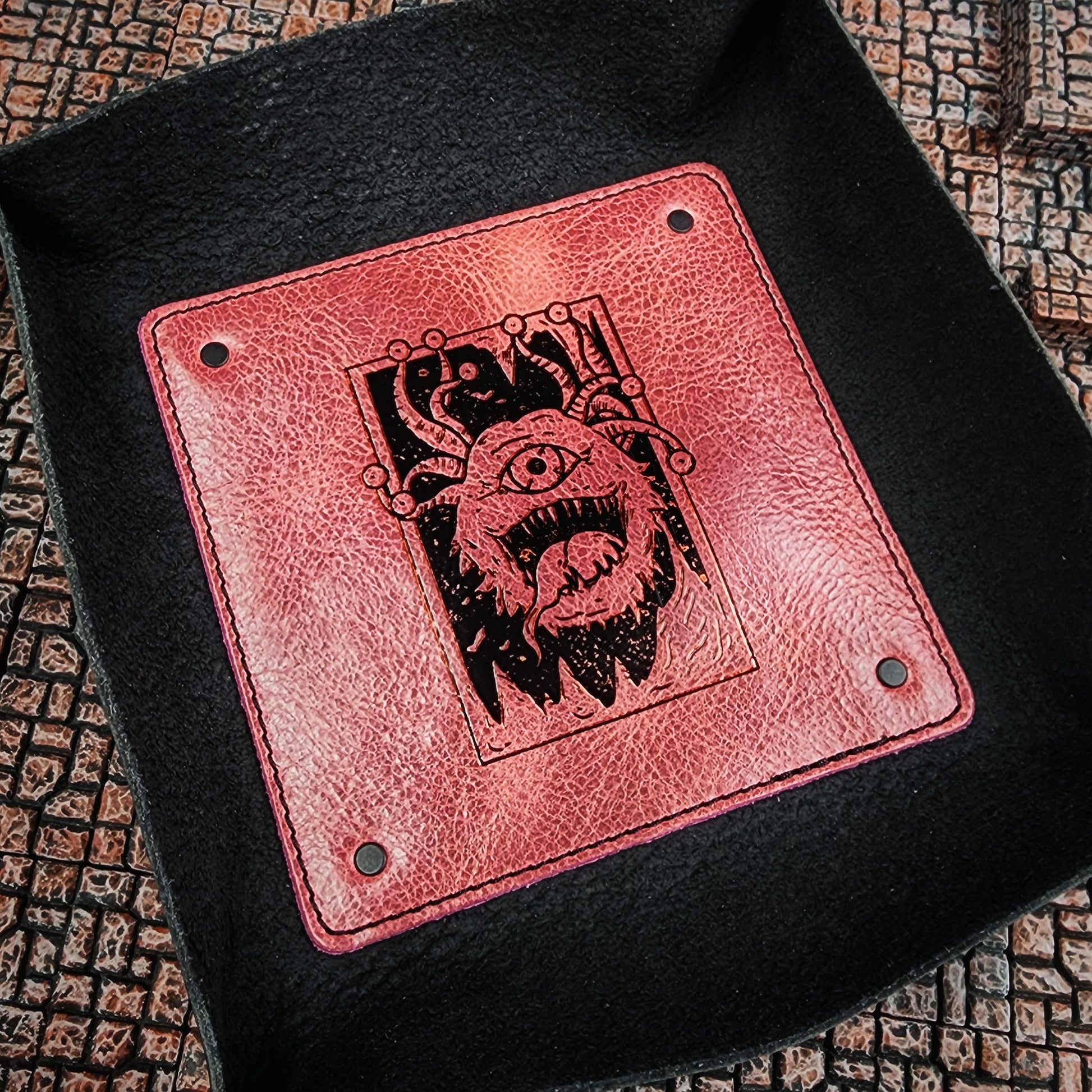 Handcrafted leather dice trays holding polyhedral RPG dice on a gaming table for D&D shops and Renaissance festival vendor booths.